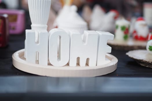 A charming white HOME sign elegantly placed on a rustic wooden tray, perfect for home decor