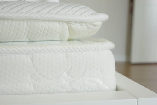 A white mattress with a knitted design and neutral tones offers a comfortable experience in a closeup view
