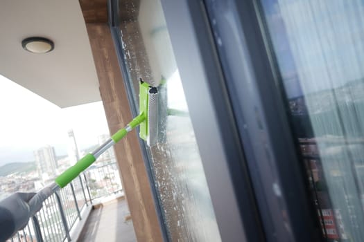 Rubber squeegee cleans a soaped window