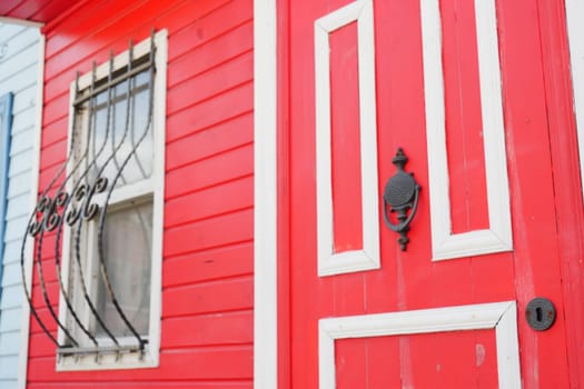 Colorful red door with stylish window grills, perfect for charming architecture.