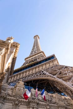 Eiffel Tower, Paris Las Vegas Hotel. Low Angle View. Blue Sunny Sky On Background. Tricolor Flag Of France And The USA. Copy Space, Vertical Plane. Las Vegas, Nevada, USA: December, 27 2024.