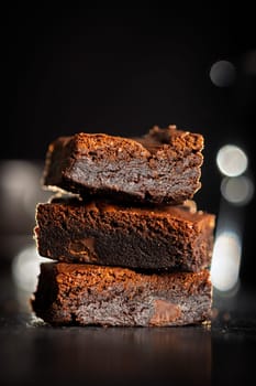 Homemade chocolate brownies on a black table.