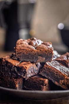 Homemade chocolate brownies on plate on a wooden table.
