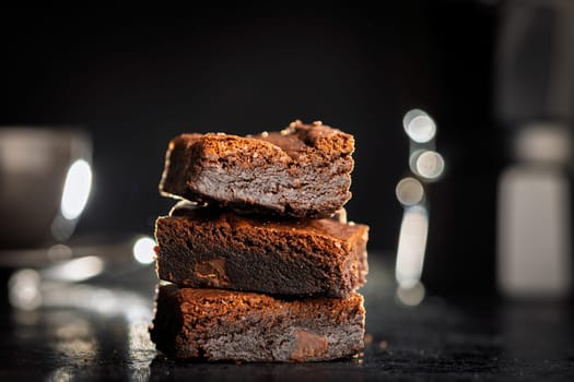 Homemade chocolate brownies on a black table.