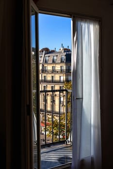 Open window overlooking the city with old buildings. Paris, France - October 24, 2024