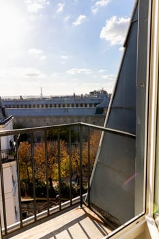 Open window with romantic view of rooftops and Eiffel Tower in Paris, France.