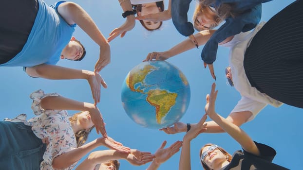 Young boys surround the globe of the world with their palms