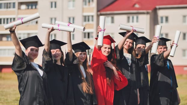 College graduates pose in the city wearing robes