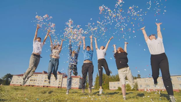 Friends toss colorful paper confetti from their hands