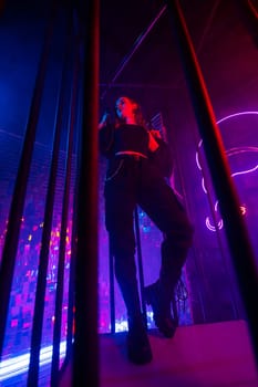 Caucasian woman in neon studio behind steel bars