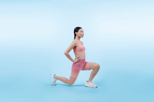 Young attractive asian woman in sportswear stretching before fitness exercise routine. Healthy body care workout with athletic woman warming up on studio shot isolated background. Vigorous