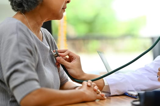 General practitioner using stethoscope checking heart and lungs of elderly patient. Medical and health care service concept.
