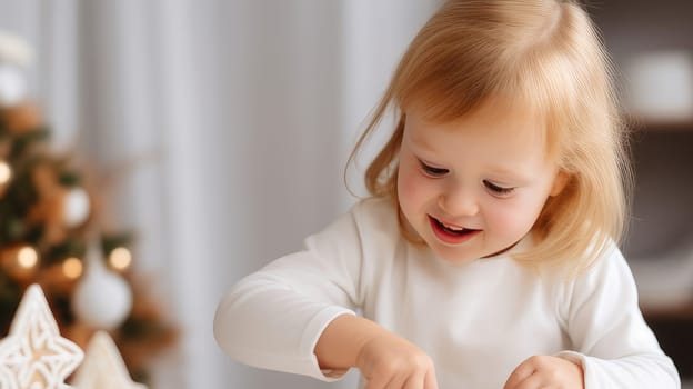 Smiling white child with down syndrome decorates Christmas cookies. Merry Christmas and Happy New Year concept