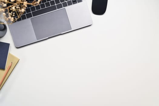 FLaptop computer, coffee mug and notebook on white background. Top view with space for text.