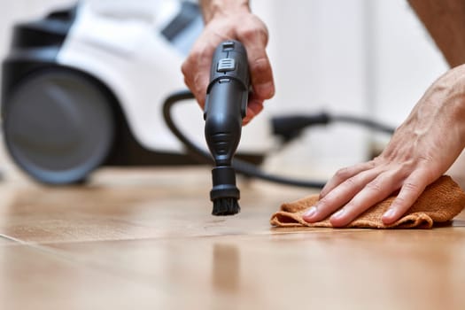 male hand with professional cleaning steam generator cleaning tiled floor, home disinfection