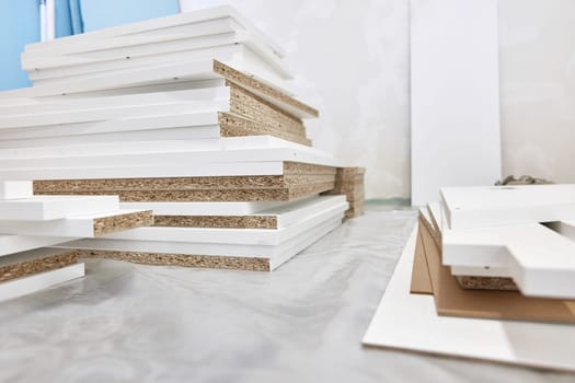 stack of white MDF panels lie on floor. Construction material.