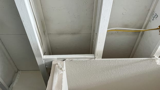 Castle Pines, Colorado USA - January 18, 2023-Close-up of exposed ceiling joists and electrical wiring in the unfinished basement of a newly constructed single-family home. The image captures the structural framework and early electrical installation, showcasing the construction progress.