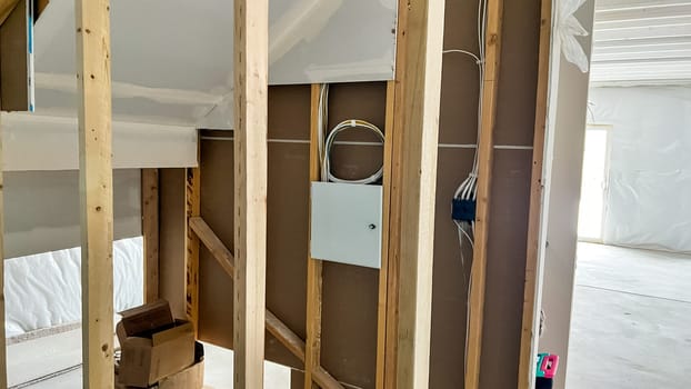 Castle Pines, Colorado USA - January 18, 2023-View of an unfinished basement in a new single-family home under construction. The image features exposed wooden framing and an installed electrical panel, showcasing the progress of electrical infrastructure in the building process.