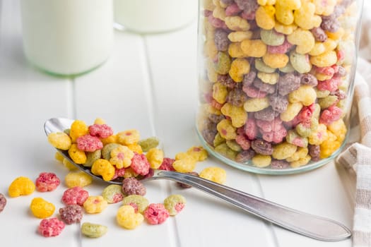 Colorful breakfast cereals in the shape of various fruit in on a white table.