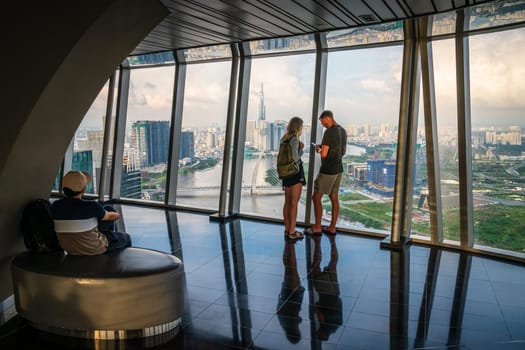 Ho Chi Minh City, Vietnam, November 24, 2022: Tourists are enjoying the aerial view of the city from the Saigon Sky Deck in Ho Chi Minh City, Vietnam