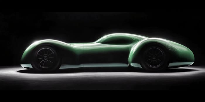 Classic green vintage race car is standing still under studio lights, showing off its elegant curves and design. The car's polished paint shines in the spotlight, highlighting its timeless appeal