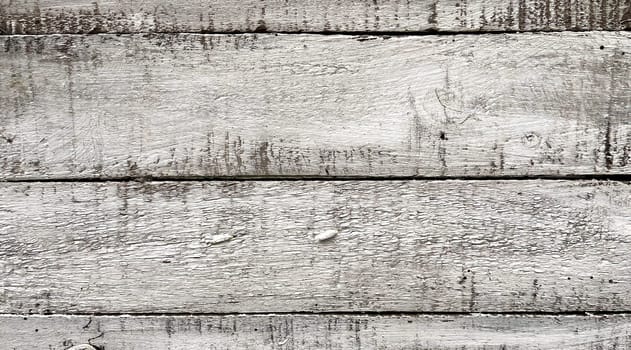 A close-up view of weathered white wooden planks. The texture of the wood is prominently displayed, showcasing the natural grain, knots, and imperfections that give it a rustic and aged appearance. The white paint is worn and chipped in places, adding to the vintage and distressed look. This background is ideal for use in design projects that require a natural, rustic, or shabby chic aesthetic.