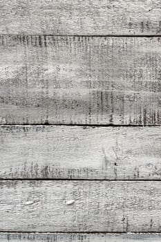 A close-up view of weathered white wooden planks. The texture of the wood is prominently displayed, showcasing the natural grain, knots, and imperfections that give it a rustic and aged appearance. The white paint is worn and chipped in places, adding to the vintage and distressed look. This background is ideal for use in design projects that require a natural, rustic, or shabby chic aesthetic.