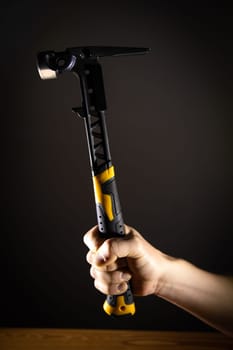 Hand holding hammer, which is perfect for an array of DIY tasks and home improvement projects