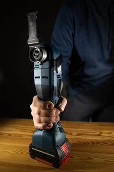 A person effectively using a reliable cordless power Multi-Cutter tool for various DIY projects and home repairs