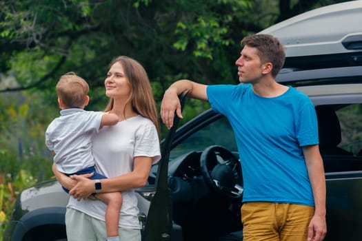 A joyful family happily enjoying their exciting outdoor adventure close to a vehicle, embraced by nature