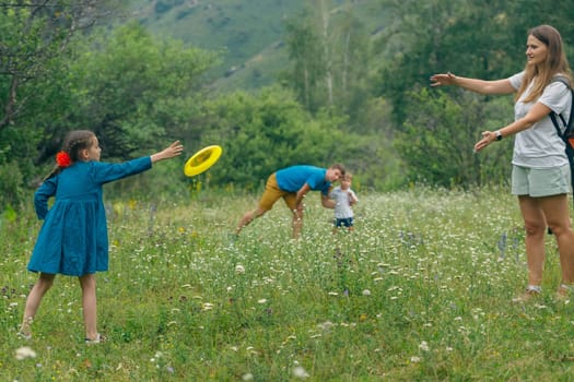 Enjoying quality family time outdoors while playing frisbee joyfully in a lush green field under the sun