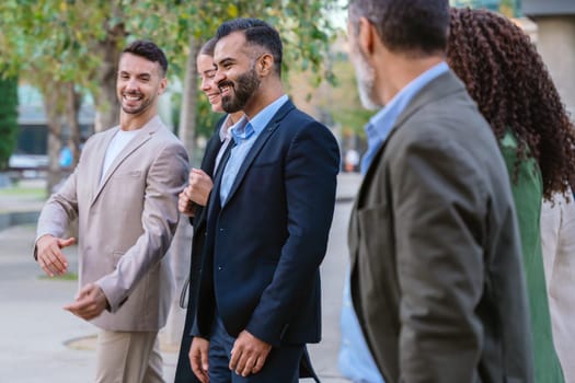 A diverse group of business professionals walking together outside a modern office building. They are engaged in conversation, dressed in formal and smart casual attire.