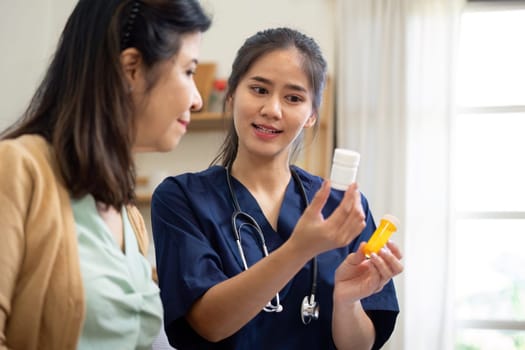 An attentive caregiver discussing the importance of proper medication use with an elderly patient in a cozy home environment, ensuring understanding and support.