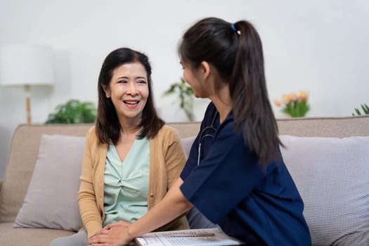 A friendly caregiver engaging in a meaningful conversation with an elderly patient, fostering a connection and providing reassurance in a comforting home atmosphere.