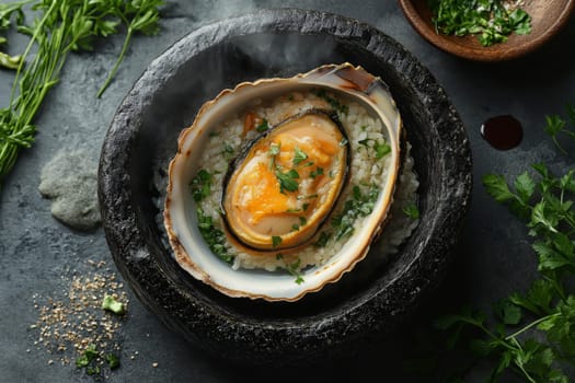 Live abalone rests in its shell, surrounded by rice and fresh herbs in a stone bowl. A culinary dish showcases vibrant colors and textures, highlighting gourmet preparation.
