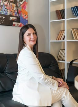 Portrait of mature business woman with arms crossed looking at camera.She is holding a white construction helmet Happy smiling mid businesswoman standing in office with copy space.