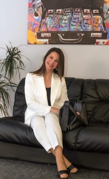 Portrait of mature business woman with arms crossed looking at camera.She is holding a white construction helmet Happy smiling mid businesswoman standing in office with copy space.