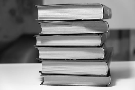 Stack of books on a white background. One book is yellow. Book reading and learning concept.