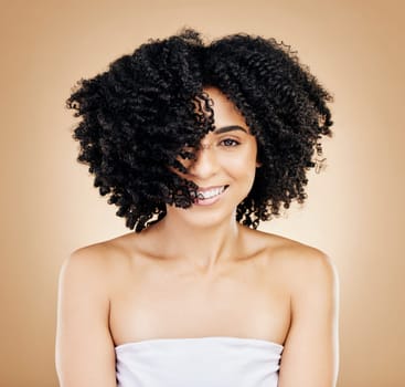 Hair, curls and portrait of woman, beauty and treatment for shine, cosmetic care and smile on studio background. Wellness, haircare and growth with strong texture and shake locks, volume and afro.