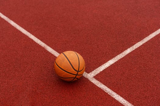 Orange basketball on brown court of gymnasium sport floor. Street basketball concept. High quality photo