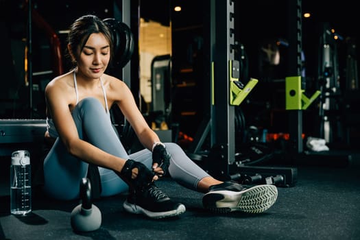 Adult young woman tying her shoelaces while wearing fashionable sneakers. The shot is perfect for lifestyle or fashion concepts