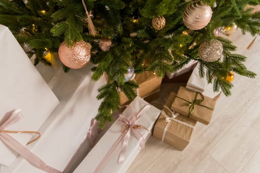 Craft gifts under the tree, on the table, against the wood background. The concept of Christmas and New Year.