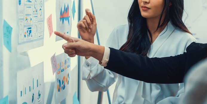 Young manager with suit pointing at whiteboard brainstorming business idea presenting data analysis to his female colleague. Finding out of solution solving the problem. closeup. Intellectual.