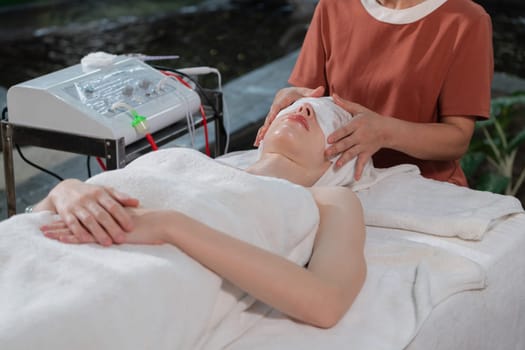 Attractive caucasian woman with beautiful skin having facial medical electrical treatment by professional doctor surrounded by natural environment. Relaxation and healthy concept. Tranquility.