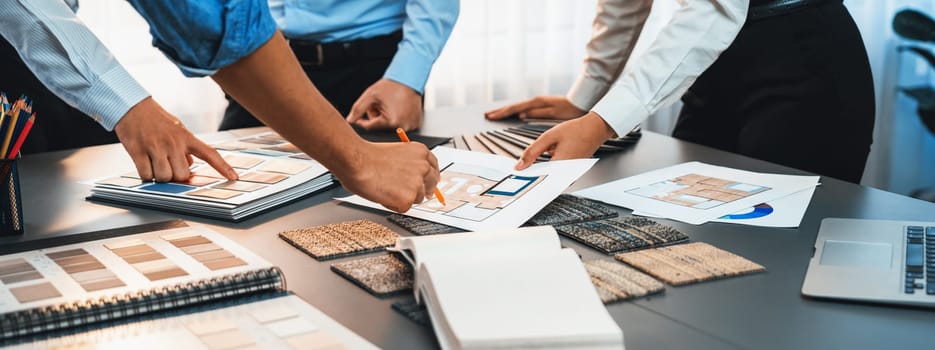 Group of interior designer team in meeting, discussing with engineer on interior design and planning for house project blueprint and model, choosing color sample and mood board materials. Insight