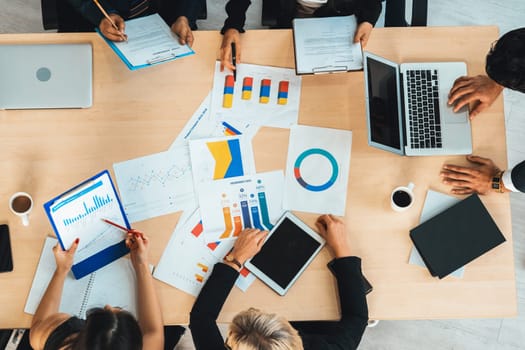 Business people group meeting shot from top view in office . Profession businesswomen, businessmen and office workers working in team conference with project planning document on meeting table . Jivy