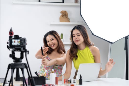 Woman influencer shoot live streaming vlog video review makeup uttermost social media or blog. Happy young girl with cosmetics studio lighting for marketing recording session broadcasting online.