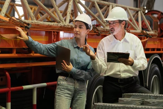 Factory manager inspecting industrial steel machinery and overseeing while supervising and enhancing quality control process for metal material product. Exemplifying