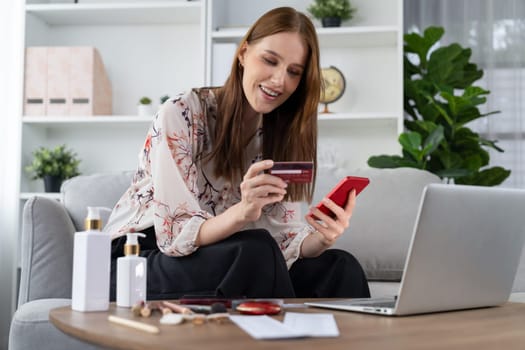 Young happy woman buy product by online shopping at home while ordering items from the internet with credit card online payment system protected by utmost cyber security from online store platform