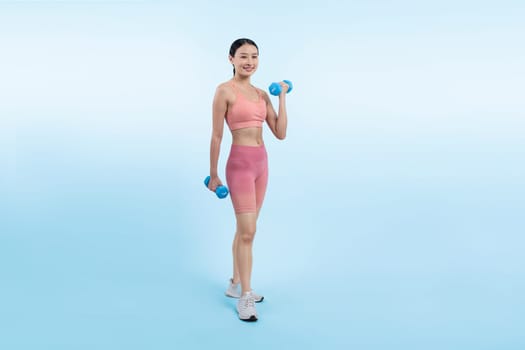 Vigorous energetic woman doing dumbbell weight lifting exercise on isolated background. Young athletic asian woman strength and endurance training session as body workout routine.